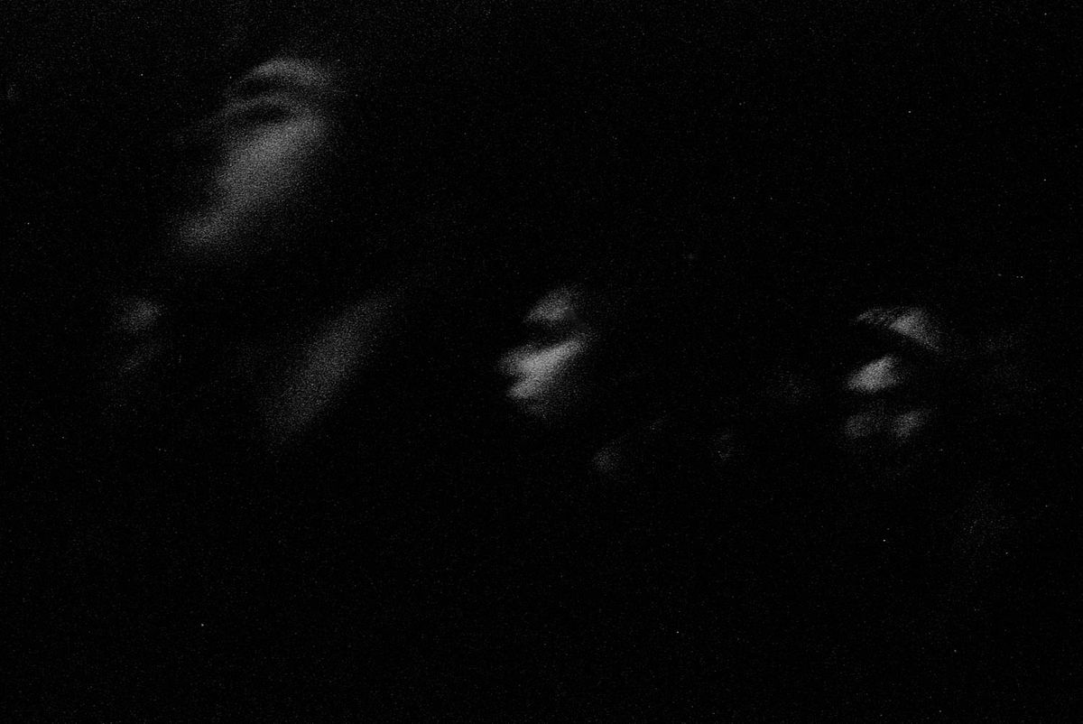 Faces in the dark, seen in profile.