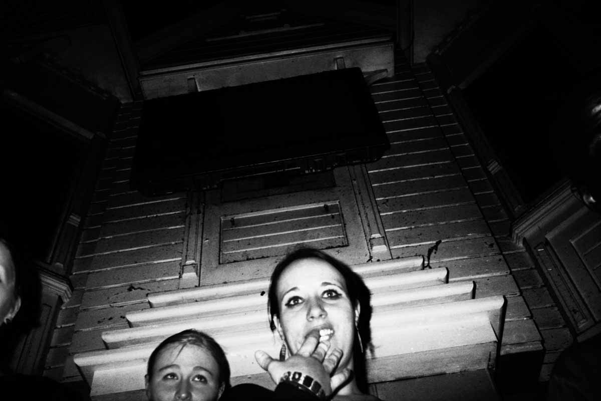 Two girls seen from below, in front of steps and a door.